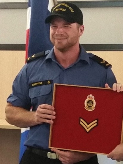 Todd Griffiths in Navy uniform, holding a framed award